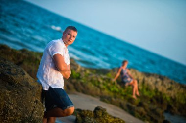 Okyanusun ve arkasında arka plan buzlu oturan beyaz gömlekli bir adam bir kadın oturuyor