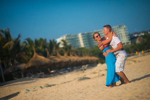 Uomo Abbraccia Una Ragazza Sulla Spiaggia Uno Sfondo Palme Cielo — Foto Stock