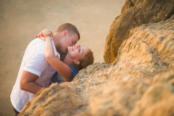 Een Man Kussen Een Vrouw Rotsen Bij Zonsondergang Het Strand — Stockfoto