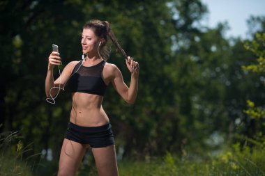 Bir genç kadın atlet onun eğitim sonuçlarını izliyor