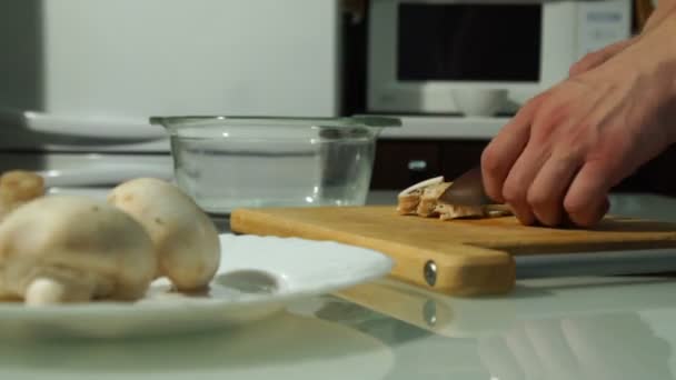 Mãos de chef masculino cortando cogumelos frescos em uma tábua de madeira — Vídeo de Stock