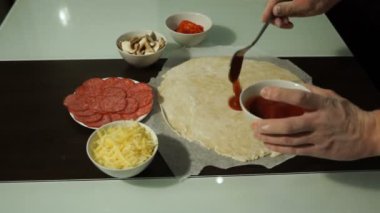 Erkek Şef kırmızı sos baharatlı pizza smear. Çiğ hamur preform