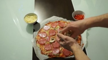 Salam ve peynir ham bir pizza üzerine koyarak mantar yemek