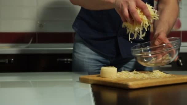 Человек наливает нарезанный сыр в тарелку — стоковое видео
