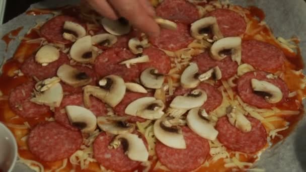 厨师把蘑菇在香肠和奶酪上的生比萨饼 — 图库视频影像