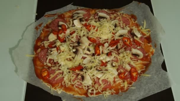 Шеф кладет сыр на сырую пиццу крупным планом — стоковое видео