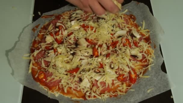 Chef coloca queijo em uma pizza crua close-up — Vídeo de Stock