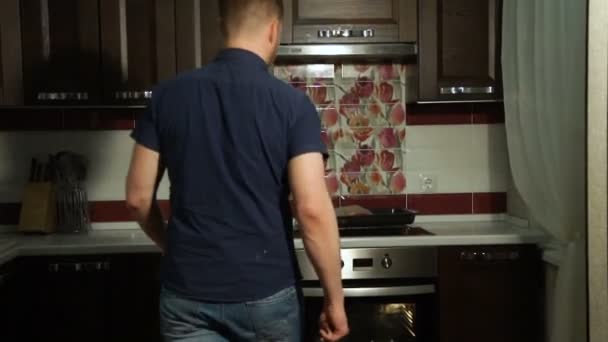 Mannelijke chef-kok legt een bakplaat met rauwe pizza in de oven. Koken pizza — Stockvideo