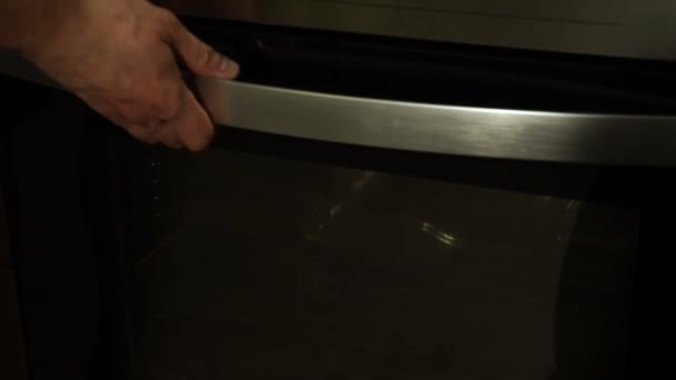 Male chef puts a baking tray with raw pizza in the oven. Cooking pizza — Stock Video