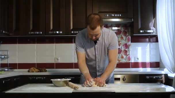 Мужские руки готовят тесто для пиццы на столе на кухне — стоковое видео