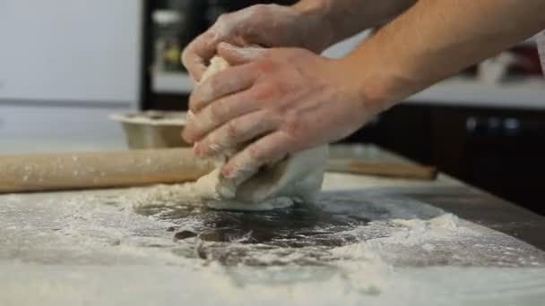 Mens mains préparer la pâte à pizza sur la table dans la cuisine 