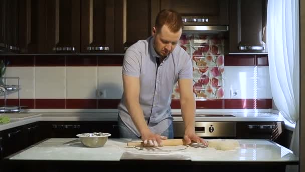 Człowiek rolki ciasta na stole w kuchni z wałkiem. — Wideo stockowe