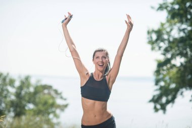 Kız elini sevinç, zafer, kazançlar, başarı ile yukarı atar. Zafer spor yarışmaları