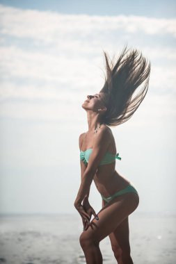 Rüzgar deniz arka planda çırpınan saçlı poz bir mayo seksi kız