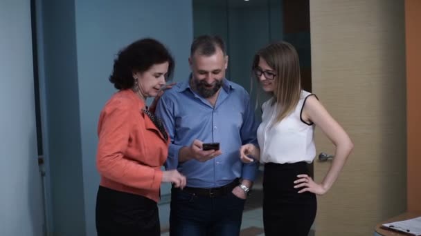 Kolegové sledovat video na chytrém telefonu a přejdete na obrazovku jsou překvapeni — Stock video