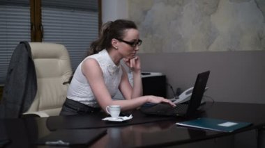 Ofisindeki kahve molası sırasında dizüstü bilgisayar üzerinde çalışan sekreter kız