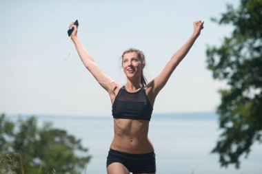 Kız elini sevinç, zafer, kazançlar, başarı ile yukarı atar. Zafer spor yarışmaları