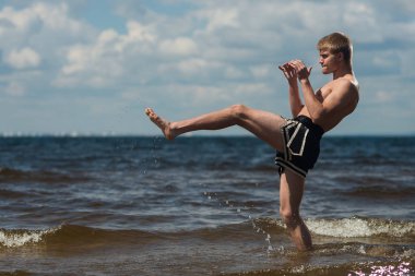 Kick boks denize karşı yaz aylarında açık havada tekmeler. Mücadele sporudur