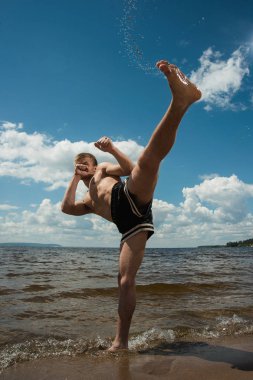 Kick boks denize karşı yaz aylarında açık havada tekmeler. Mücadele sporudur