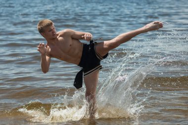 Kick boks denize karşı yaz aylarında açık havada tekmeler. Mücadele sporudur
