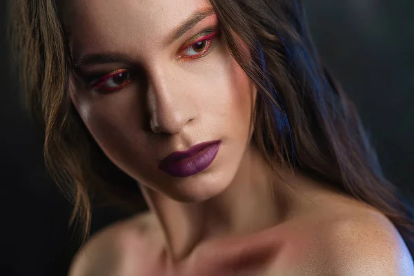 Beauty Women Face. Beautiful young model with bright face makeup. Portrait of sexy girl with purple lips