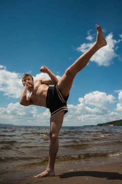 Kick boks denize karşı yaz aylarında açık havada tekmeler. Mücadele sporudur
