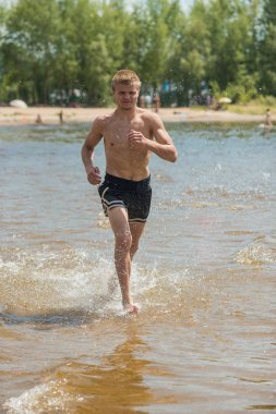 Genç bir adam sahilde eğitim. Sabah koşuya temiz havada bir genç adam