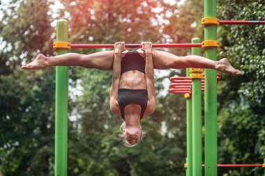 kız açık havada yatay çubuğu'nda yapıyor. Kadın olarak çalışma yapmaktadır