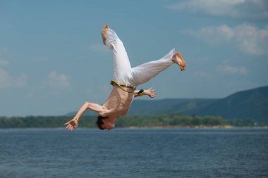 Acrobat akrobatik bir hüner, takla sahilde gerçekleştirir.