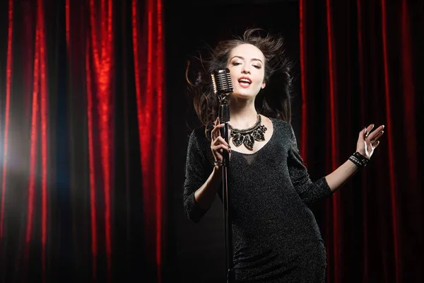 Νέοι Όμορφη Τραγουδίστρια Μαύρο Φόρεμα Ρέει Μαλλιά Τραγουδάει Στο Μικρόφωνο — Φωτογραφία Αρχείου