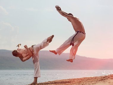 Erkekler capoeira sahilde - kavramı kişi, yaşam tarzı ve spor hakkında eğitmek. Eğitim iki savaşçıları