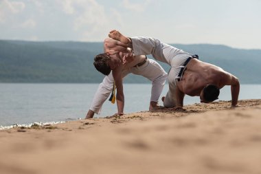 Erkekler capoeira sahilde - kavramı kişi, yaşam tarzı ve spor hakkında eğitmek. Eğitim iki savaşçıları