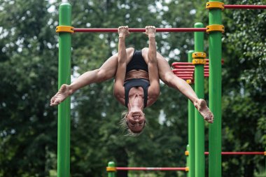 kız açık havada yatay çubuğu'nda yapıyor. Kadın olarak çalışma yapmaktadır