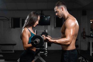 Halter kaldırma spor salonunda tren adam eğitmen ve kadın