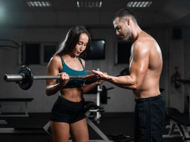 Halter kaldırma spor salonunda tren adam eğitmen ve kadın