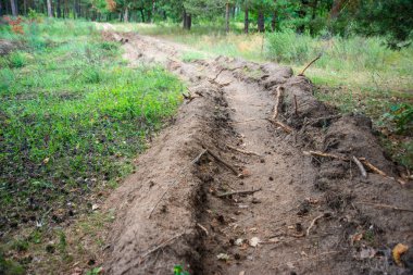 Arazi ve orman iletişimi boru döşeme boşaltmak için uzun bir siper çıkardı