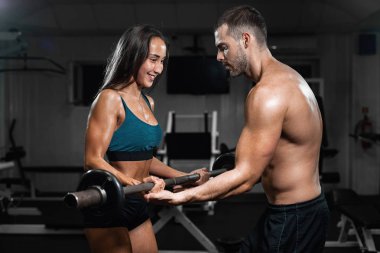 Halter kaldırma spor salonunda tren adam eğitmen ve kadın