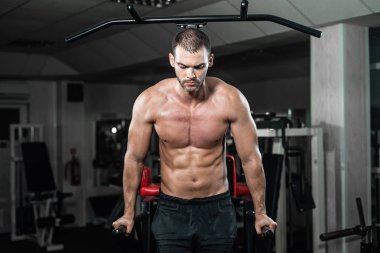 Kaslı adam crossfit spor salonunda Asimetrik paralel olarak şınav. Egzersiz yaşam tarzı kavramı