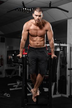 Kaslı adam crossfit spor salonunda Asimetrik paralel olarak şınav. Egzersiz yaşam tarzı kavramı