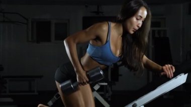 Jimnastik salonu kadın trenler. Onun pazı pompa dambıl, trenlerle atletik kadın