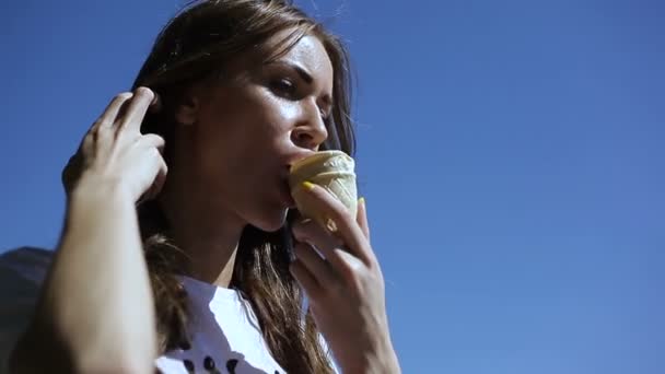 Młoda dziewczyna jedzenia lodów na zewnątrz w lecie, w upał — Wideo stockowe
