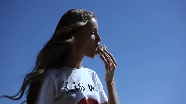 Young girl eating ice cream outdoors in summer, in heat — Stock Video