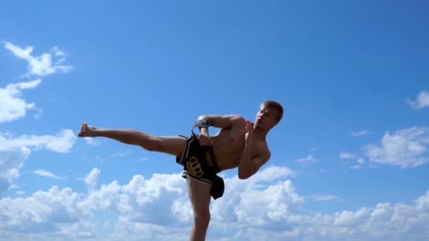 Ryssland, Togliatty - 11 juli 2018: Kickboxer sparkar utomhus i sommar på himmel bakgrund — Stockvideo