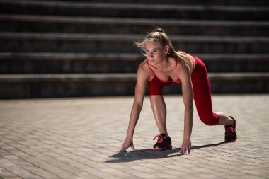 Runner güzel genç kadın start pozisyon stadyumda yaz aylarında