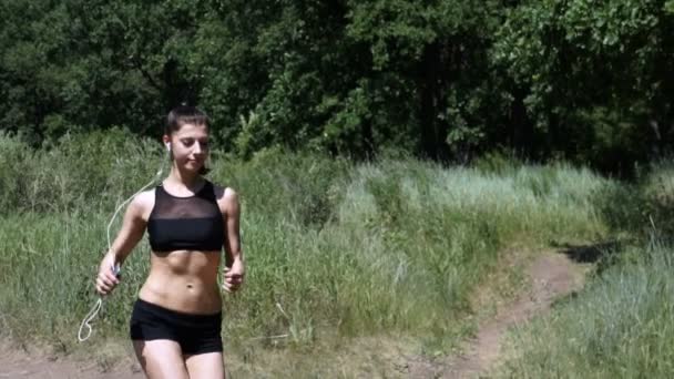 Giovane donna che corre nel bosco. La ragazza è impegnata in sport . — Video Stock