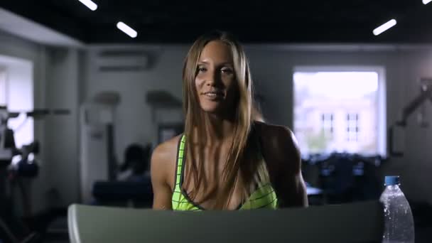 Schönes Mädchen, das im Fitnessstudio auf dem Laufband läuft, gesundes Lifestylekonzept — Stockvideo