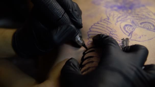 Konstnären drar en tatuering på bröstet av en man-närbild — Stockvideo