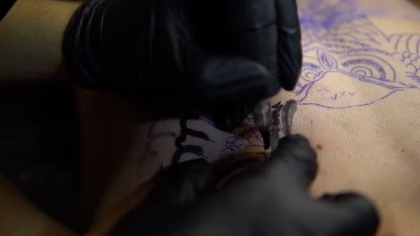 Художник рисует татуировку на груди крупным планом — стоковое видео
