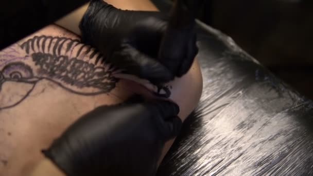 Konstnären drar en tatuering på bröstet av en man-närbild — Stockvideo