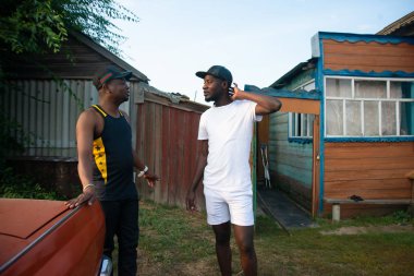 İki zenci iş konularında bir köy evinin arka plan üzerinde tartışmak.